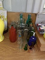 Group shot of assorted glass bottles, vases, porcelain bowl and packaged hardware
