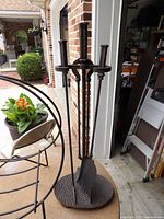 Full view of cast iron fireplace tool stand with three tools