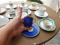 Group of assorted demitasse cups and saucers on table