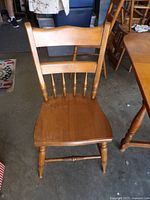 Front view of one spindle-back chair showing seat, backrest, legs