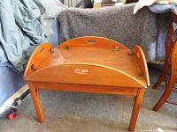 Front and side view of butler table showing raised leaves and glass panel