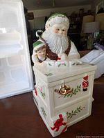 Front view of Lenox Santa cookie jar beside original foam insert