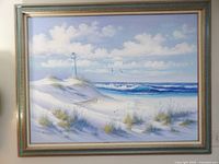 Full view of framed lighthouse shoreline painting