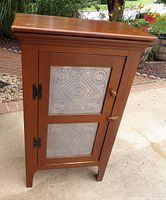 Front view of wooden cabinet with punched-tin panels