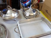 Overview of two round silver-plate covered servers and rectangular Pyrex dish in carrier