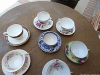 Seven teacup and saucer sets on round table