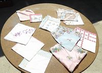 Assorted vintage floral and monogrammed handkerchiefs spread on table