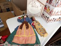 Two larger dolls and partial view of backdrop and boxes