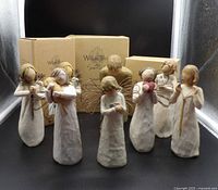 Front view of eight Willow Tree figurines and three boxes