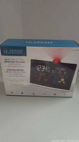 Front box image of La Crosse Technology Wi-Fi Projection Weather Station and Clock featuring the product depiction with color display screen and projected time.