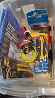 Plastic bin with various hand tools including wire strippers, clamps, extension cords, electrical tape
