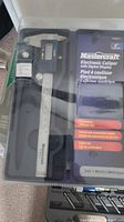 Mastercraft electronic caliper in black case with packaging showing features such as LCD display and metric/SAE conversion.