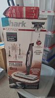 Photo of boxed Shark Genius Steam Pocket mop with washable mop pads prominently displayed.