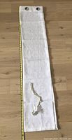 Single white sheer curtain panel laid flat with measuring tape showing approximately 58 inches in length.