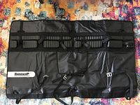 Full view of the Rhinowalk black padded bike rack cover with straps for securing bikes on a pickup tailgate.