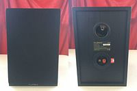 Front and back view of one Fluance SX6 speaker showing grille, bass reflex port, and binding posts.