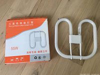 Photo showing the 55W 2D fluorescent tube light bulb next to its packaging box indicating 'Three primary colors bright lamp'.