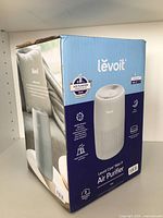 Box front showing Levoit Core Mini P Air Purifier branding, highlighting key features like 3-stage filtration and aromatherapy.