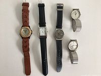Front view of 5 watches showing different styles and bands including leather and metal.