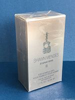 Front view of sealed shiny box with guitar icon and product details.