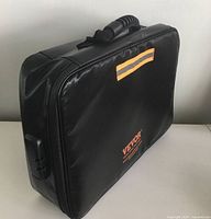 Front angle view of closed black VEVOR fireproof document box with handle and combination lock on the side.