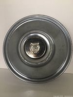 Top view of one Jaguar XJ6 Series 2 hub cap showing circular metal design with central jaguar emblem.