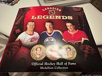 Front cover of the collectible folder titled 'Canadian Legends' with images of three Canadian NHL players and three medallions shown at bottom