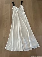 Full length image of the ivory maxi dress laid flat showing its drape and length.