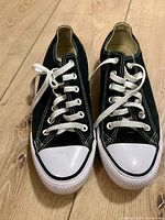 Front view of the pair of black and white Converse Chuck Taylor All Star shoes with white laces.