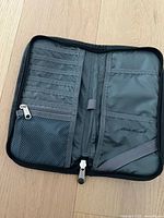 Open view of Eddie Bauer travel organizer showing card slots, mesh zipper pocket, pen loop, and other compartments