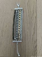 Top down image of Jenny Bird bracelet displaying multiple mixed metal chains, silver and gold, with clasp and extension chain visible for length adjustment.