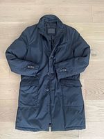 Full view of black Massimo Dutti down coat, showing exterior features such as buttons and pockets.