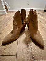 Front view of the tan suede leather ankle boots showing shape and heel height
