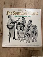 Front cover of The Sound of Music Original Broadway Cast vinyl LP showing cast photo including a woman playing guitar with several children around her in costume.