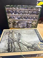 Two Cobble Hill 1000-piece puzzles, china shelf design and winter tree design