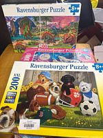 Front view of three Ravensburger puzzle boxes showing themes and piece counts
