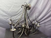 Full view of 6-arm brushed nickel chandelier with candle sleeves and bulbs