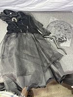 Full view of black and grey witch costume dress with packaged hat