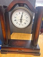 Front view showing wood case, dial, Roman numerals