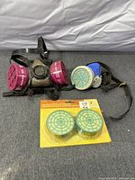 Respirator mask, installed magenta filters, sealed spare cartridge pack
