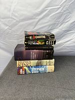 Stack of six Stephen King books showing spines: Christine, Cell, Under the Dome, plus three additional paperbacks