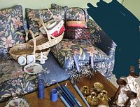 Overview of baskets, tin, candles, candlesticks and plates on couch and coffee table