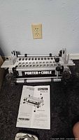 Full view of Porter-Cable dovetail jig standing upright with instruction manual in front