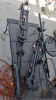 Two Yakima roof-mounted bike racks on metal table showing full structure and hardware