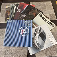 Stack of 18 Buick brochures spread out