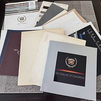 Overhead view of multiple Cadillac brochures spread out