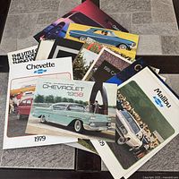 Stacked view of multiple Chevrolet brochures showing front covers for Chevette, Chevrolet 1958, Malibu, etc.