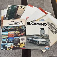 Stack of assorted Chevrolet brochures fronted by 1975 Camaro and 1975 El Camino covers