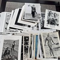 Overview of multiple stacks of photographs laid on table