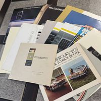 Stack of assorted Lincoln and Mercury brochures showing covers, mix of sizes